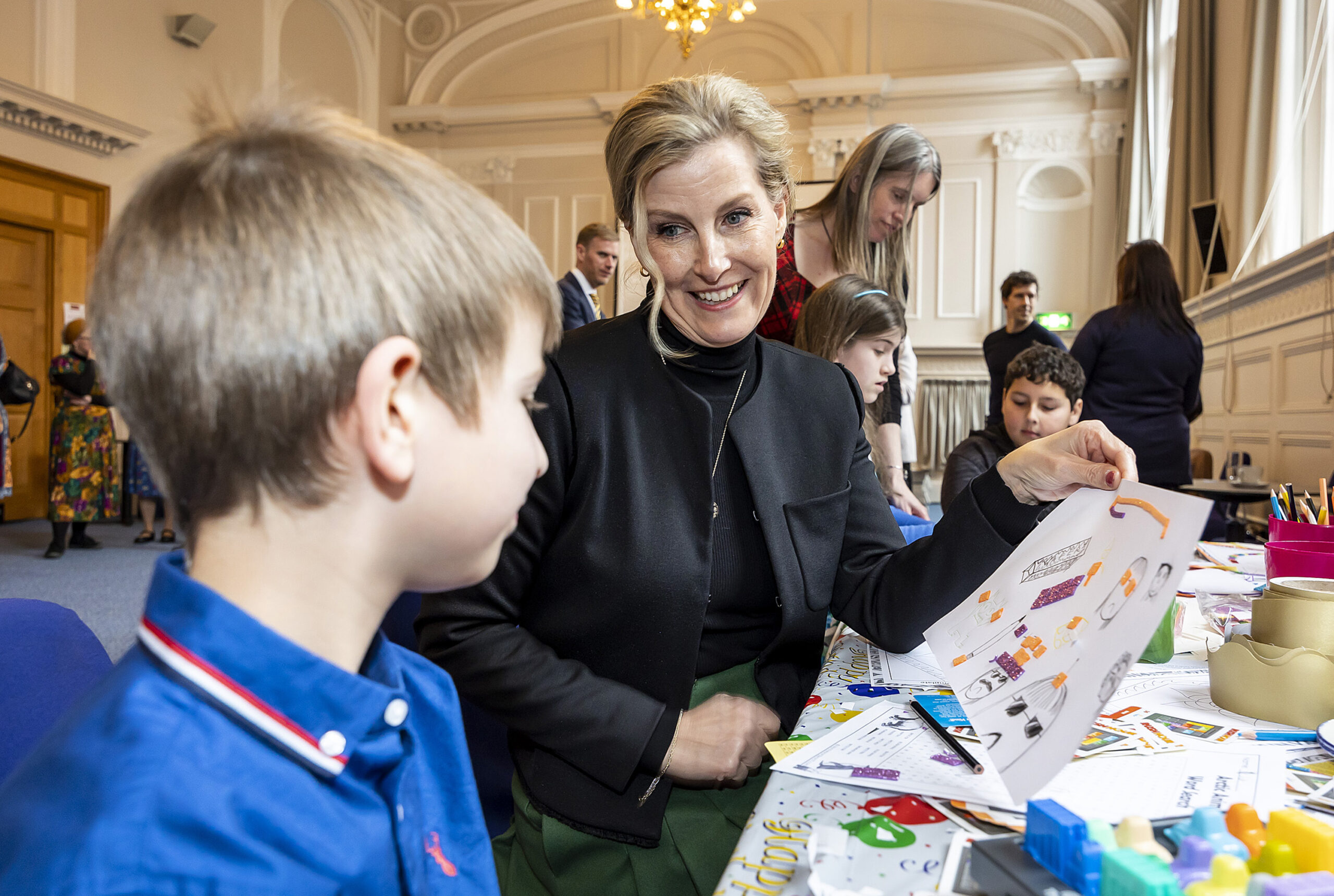 A photograph of HRH The Countess of Wessex looking at some craft with some children