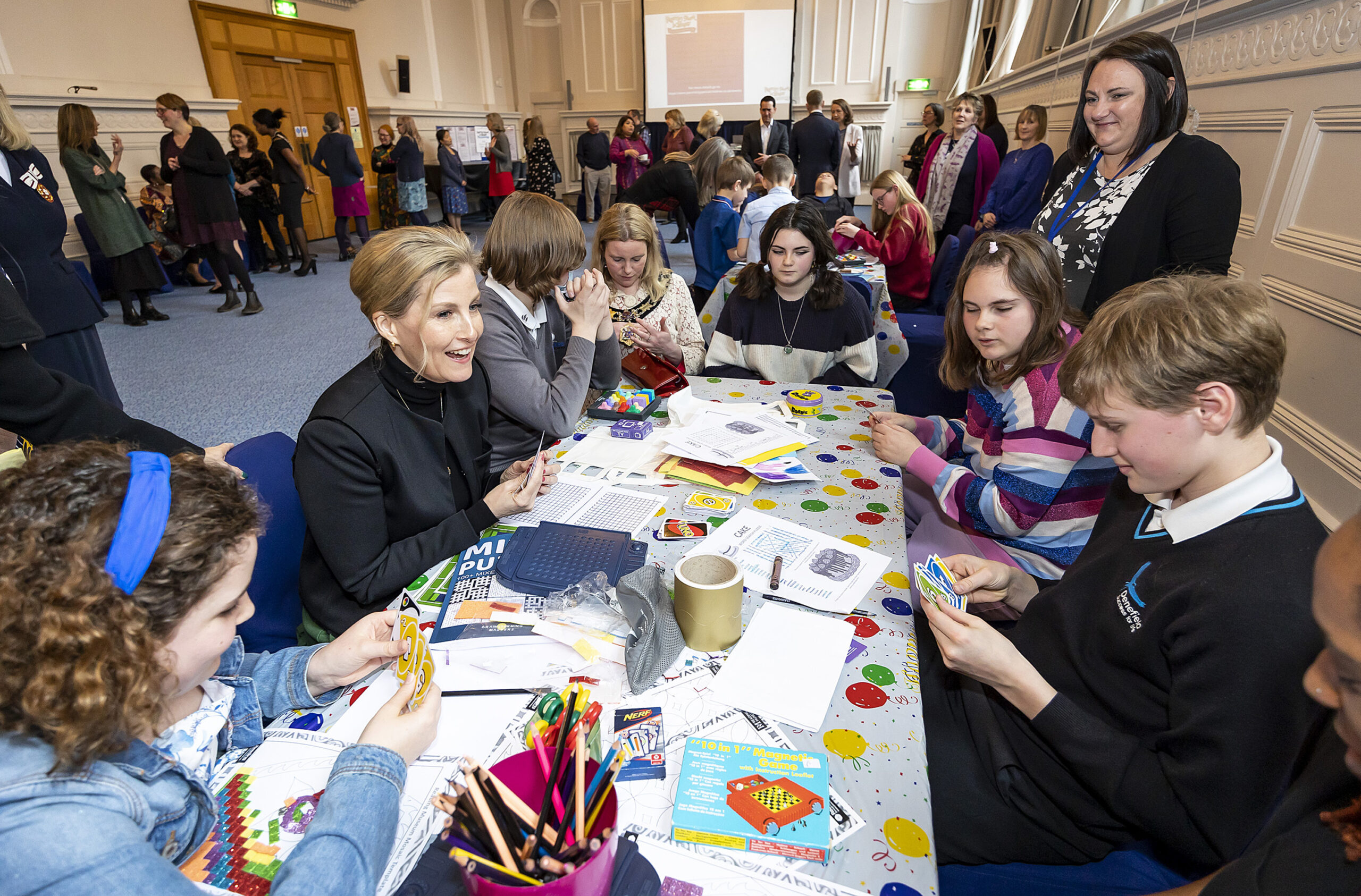 A photograph of HRH The Countess of Wessex playing uno with some children