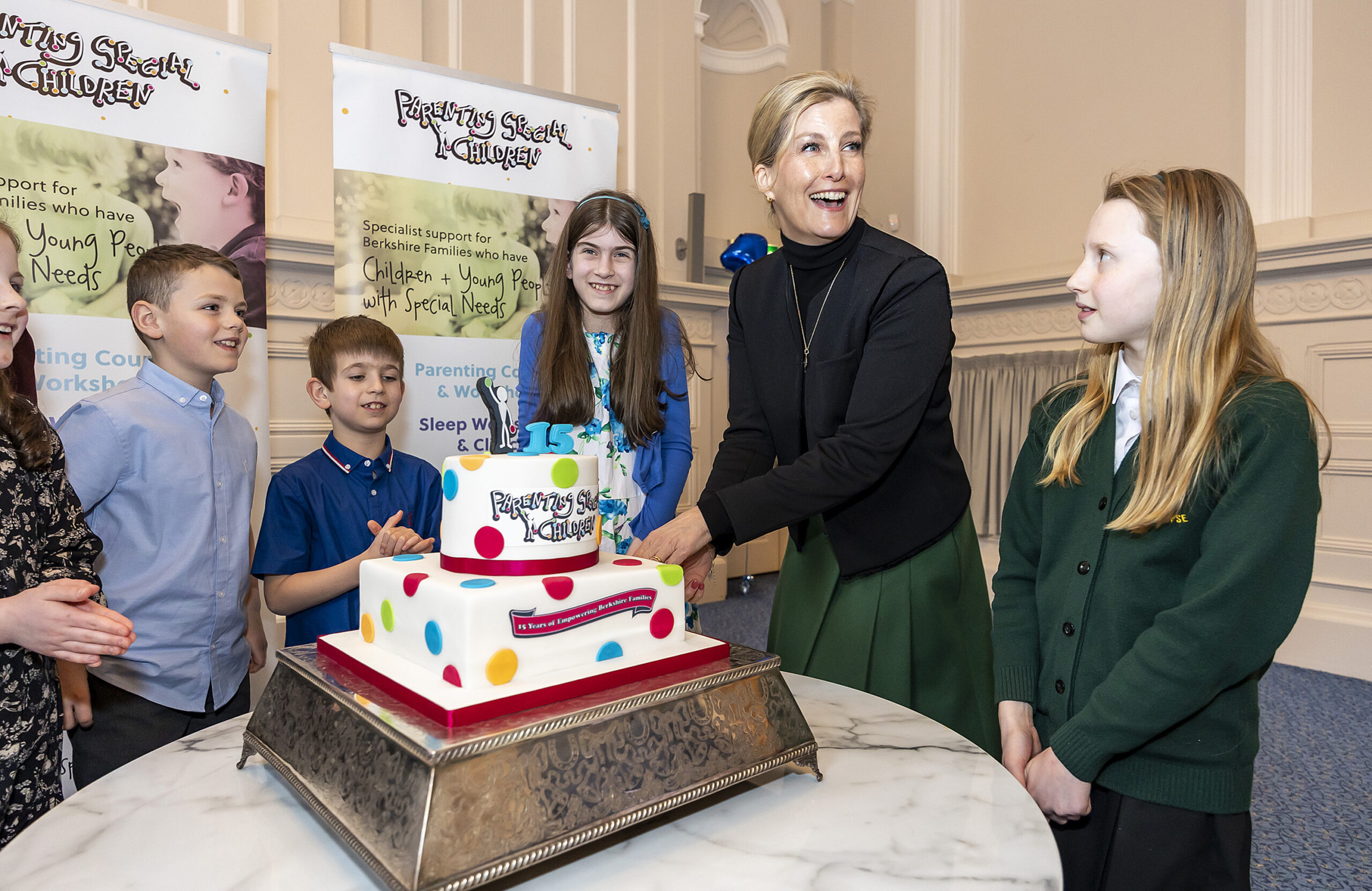 Photograph of HRH The Countess of Wessex and a group of children & young people surrounding a PSC birthday cake