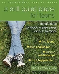 [The cover of "A Still Quiet Place for Teens" by Amy Saltzman, MD, displays a casual scene with a close-up of a teen's lower body lying on grass. The teen wears blue jeans and classic black and white Converse sneakers. The background is a lush green lawn. The text is colored in various shades of green and mentions the book as a mindfulness workbook designed to help teens ease stress and manage difficult emotions. It highlights benefits such as finding focus, facing challenges, improving relationships, and leading a happier life.]